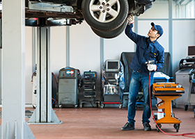 Mechanic inspecting car covered by auto insurance in Farmingdale NY