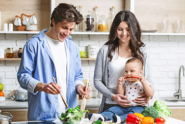 a family making dinner smiling because they have Insurance in Queens, NY, Deer Park, Brooklyn, Babylon, Massapequa, Amityville